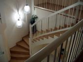 Untergurtiges Treppengeländer für bauseits geflieste Betontreppe, komplett weiß deckend lackiert. Stäbe kreisrund M22 im Wechsel mit 22 mm starken Edelstahlsträben. Massive V2A-Kugeln auf Pfosten.